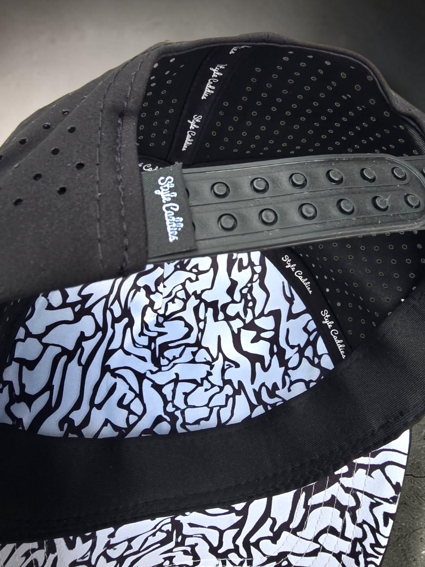 Black Style Caddies hat worn outdoors on a city plaza boardwalk