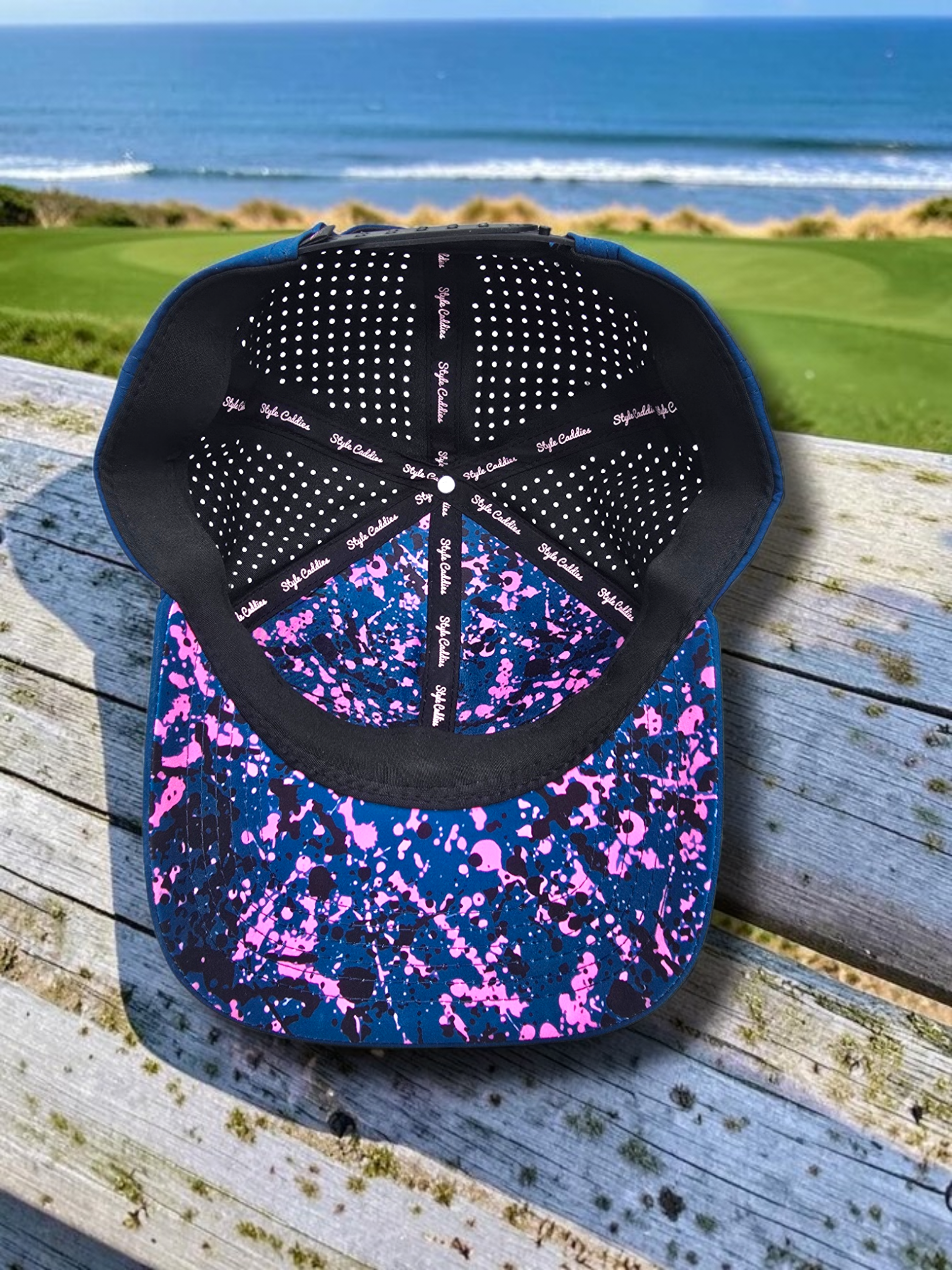 Navy Style Caddies hat underside view showing the adjustable snap strap and splatter print brim