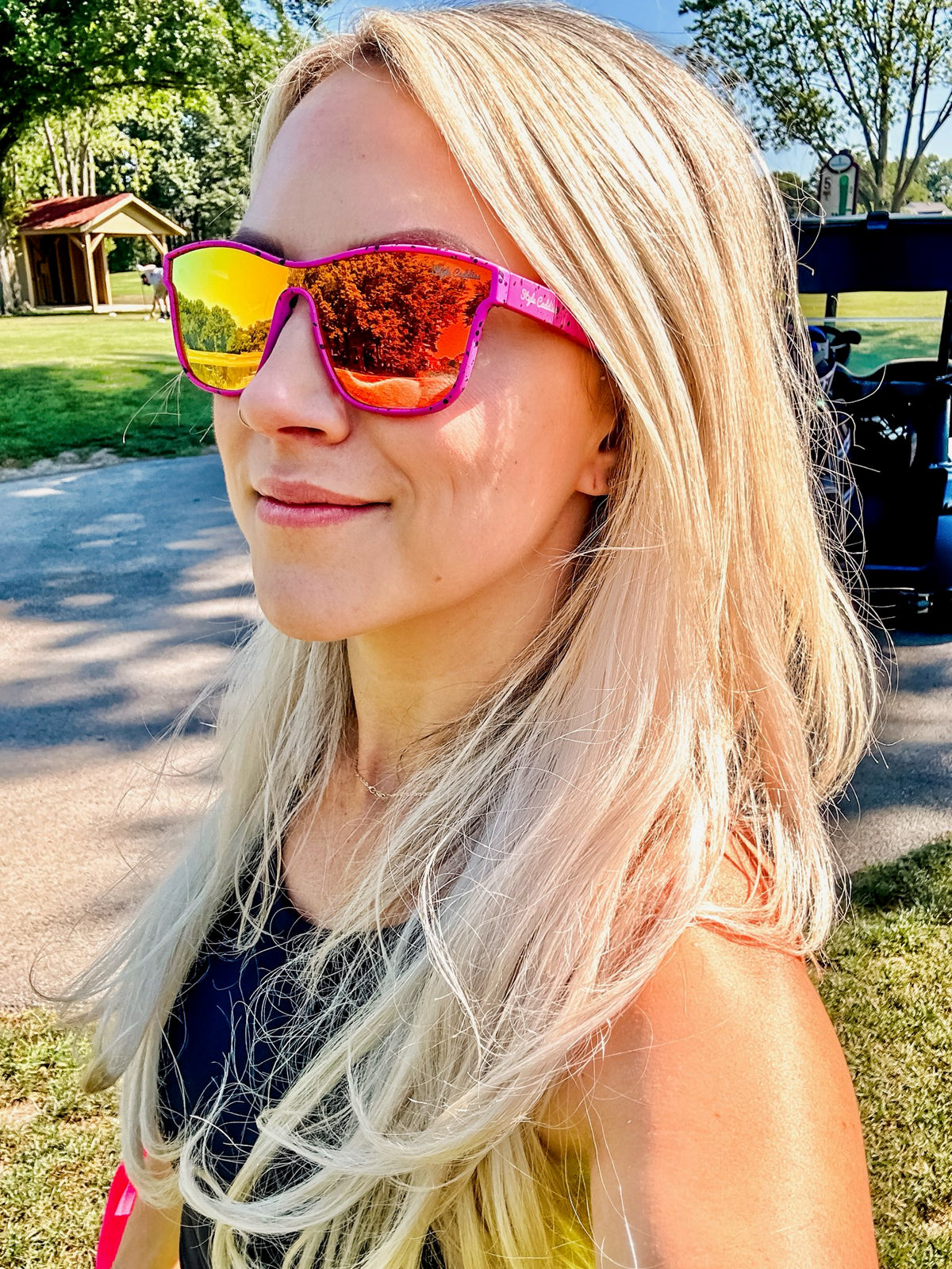 Pink paint splat golf sunglasses lifestyle shot outdoors