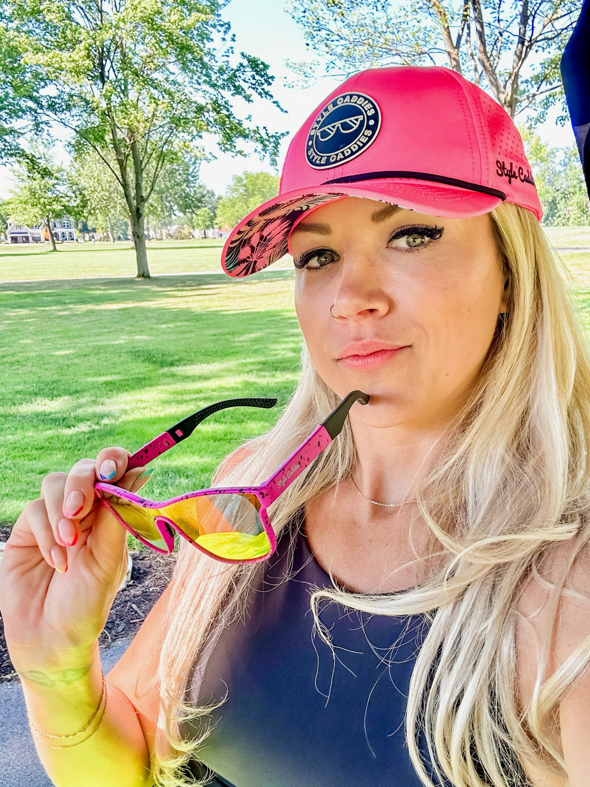 Pink paint splat golf sunglasses worn on course